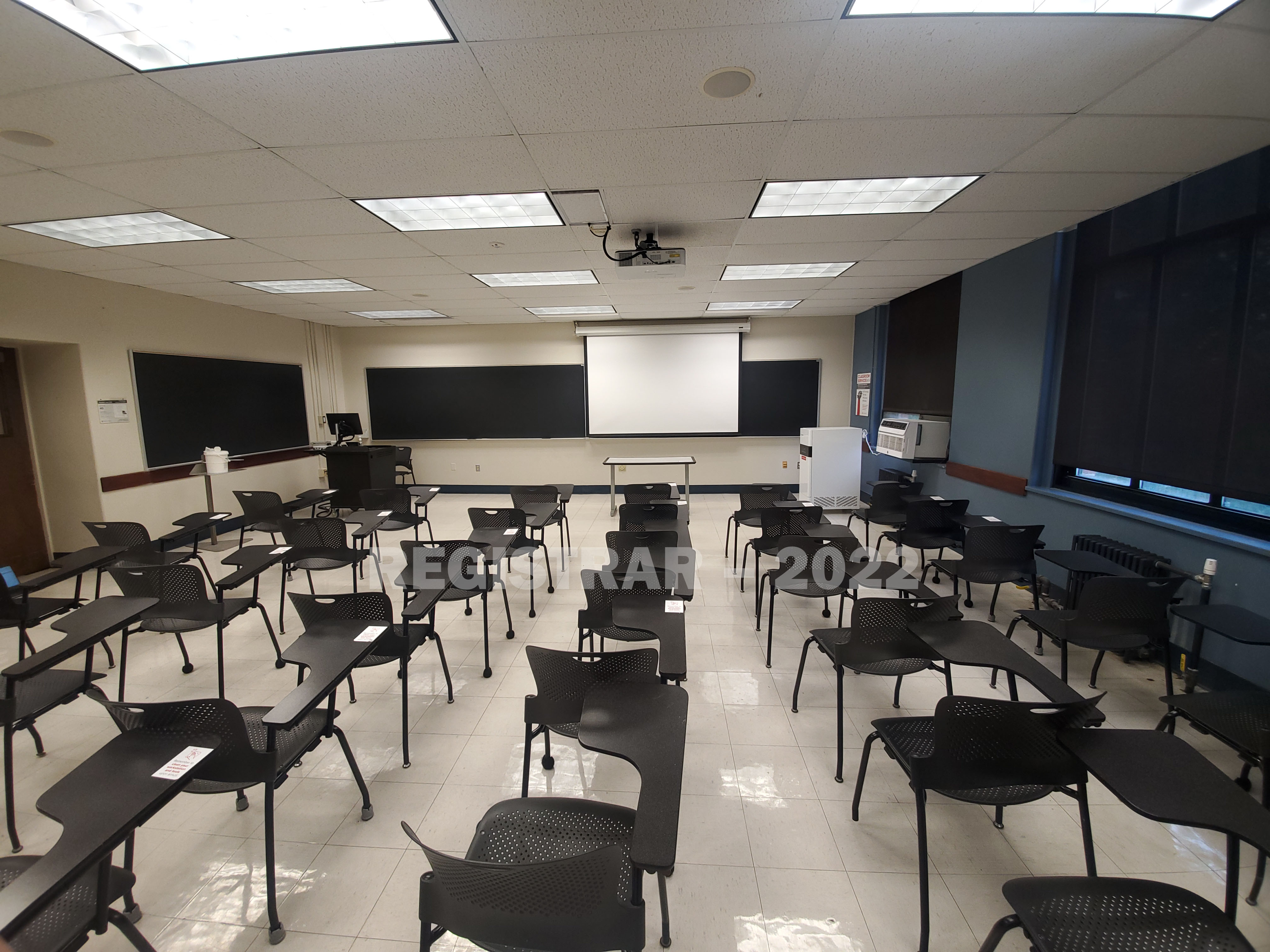 Cockins Hall room 232 ultra wide angle view from the back of the room with projector screen down