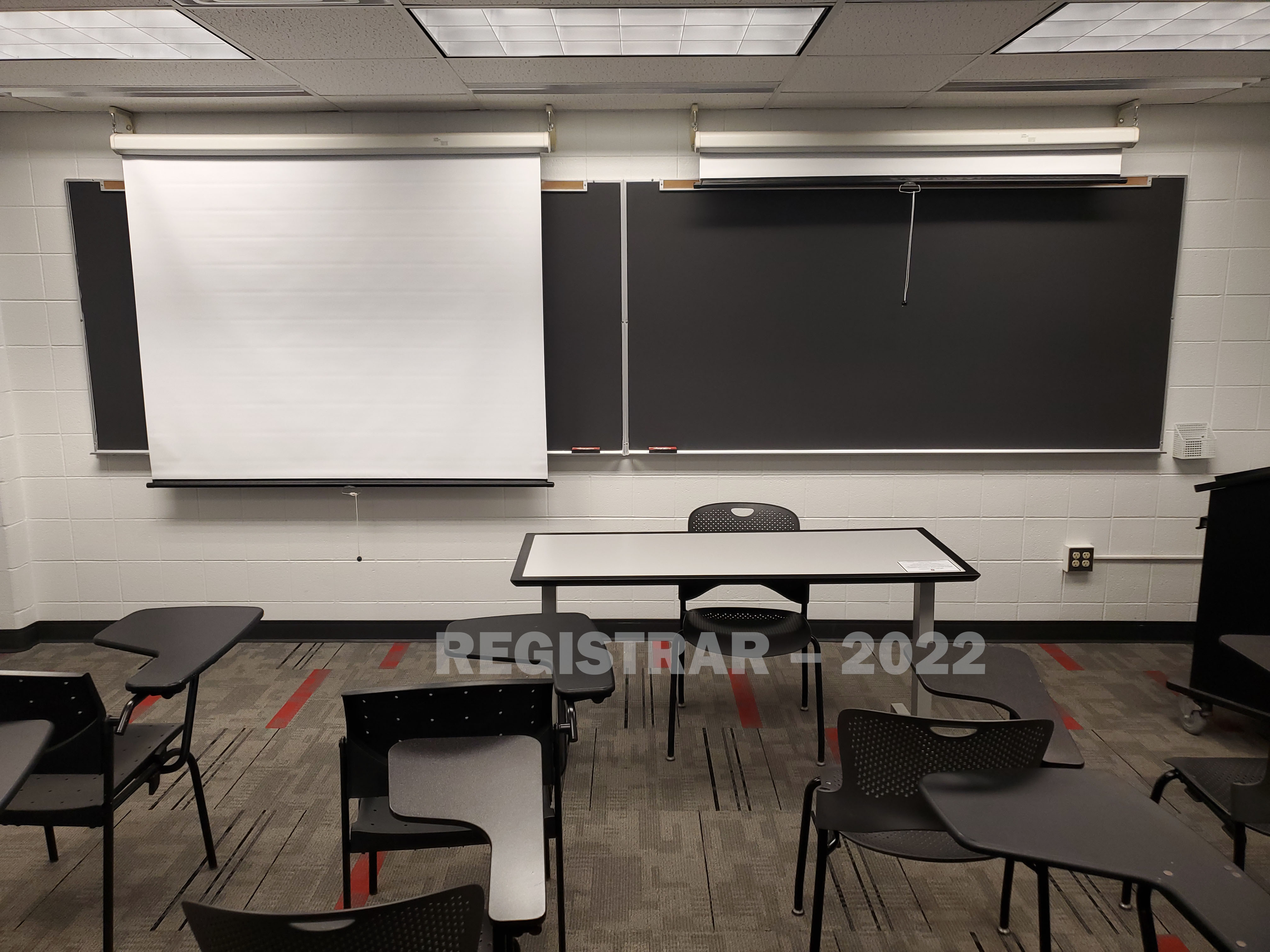 University Hall room 74 view from the back of the room with projector screen down