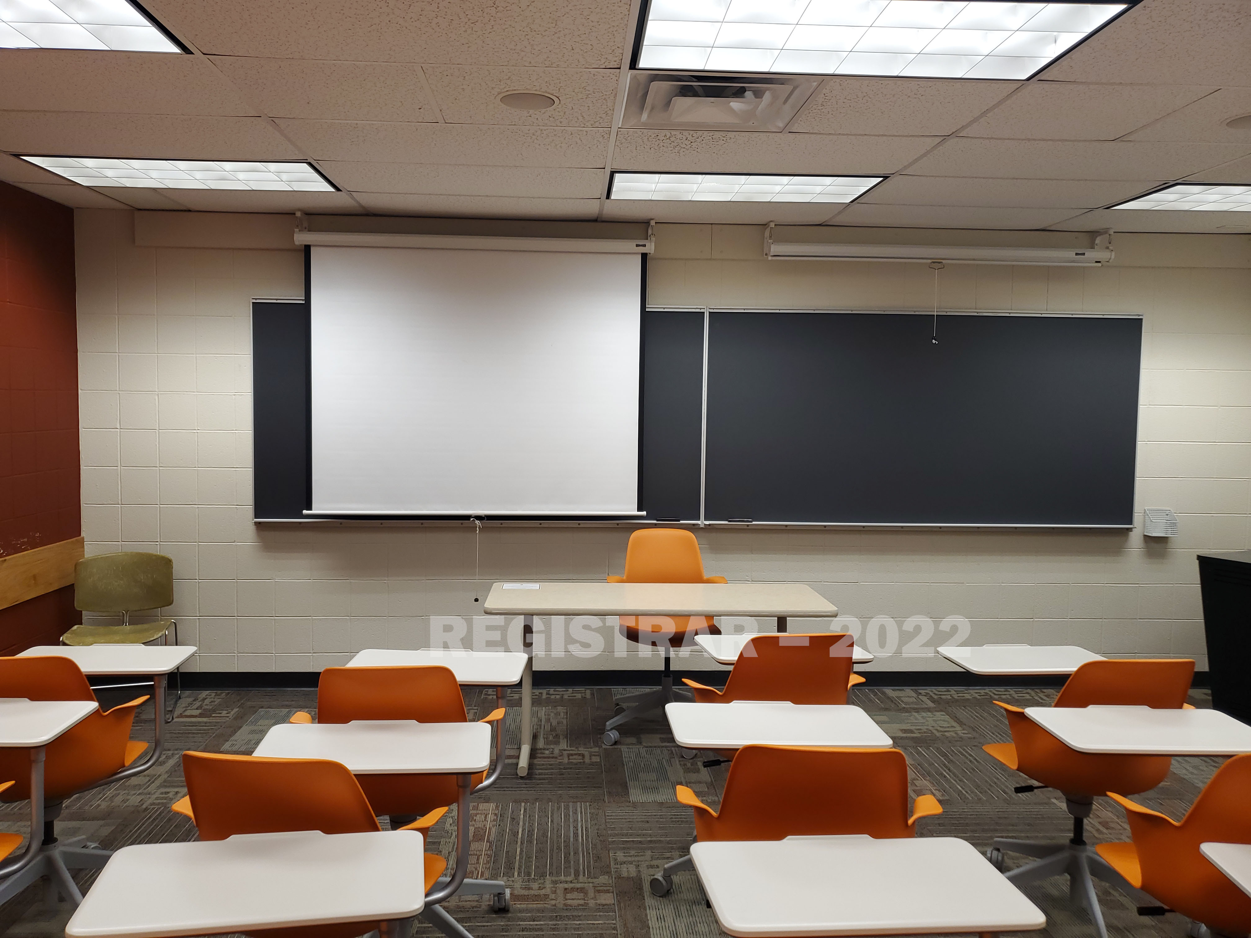 Dulles Hall room 27 view from the back of the room with projector screen down